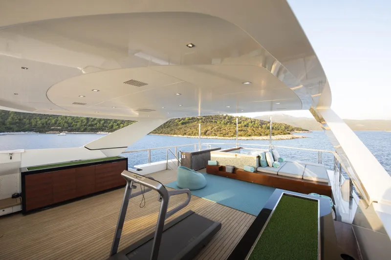 Serenity Yacht Photos Pics Luxurious Mondomarine SF40 yacht deck with modern seating, treadmill, and scenic ocean view.