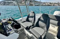 2022 Quarken 27 T-Top boat interior with dual seats, steering console, and scenic coastal view.