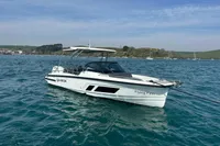 Quarken 27 T-Top 2022 boat on calm blue water with scenic background.