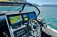 2022 Quarken 27 T-Top boat dashboard with navigation screens, steering wheel, and ocean view.
