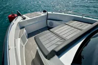 2022 Quarken 27 T-Top boat on serene water with scenic coastal backdrop.