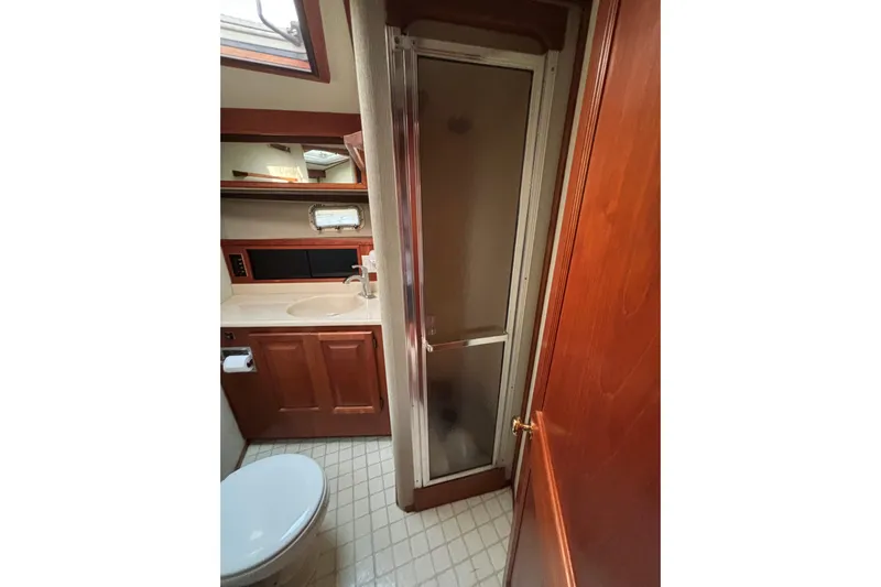  Yacht Photos Pics Bathroom interior of 1986 Viking 48 Convertible yacht with shower and wooden cabinetry.