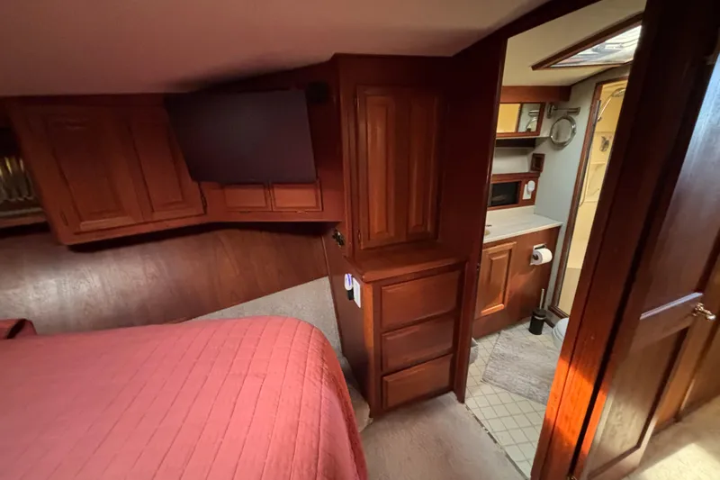  Yacht Photos Pics 1986 Viking 48 Convertible yacht interior with wood cabinetry and cozy bedroom.