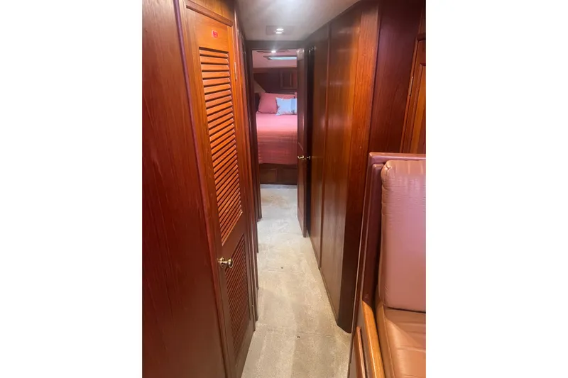  Yacht Photos Pics Interior hallway of 1986 Viking 48 Convertible yacht with wooden paneling and carpet.