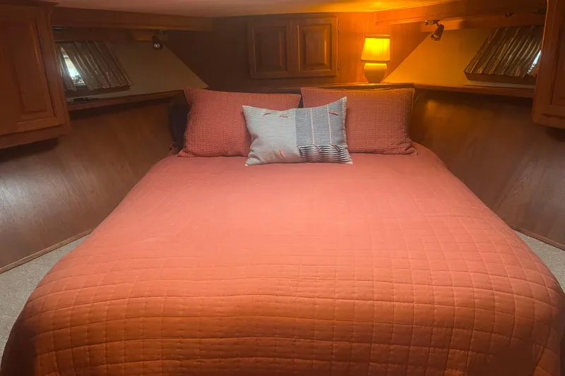  Yacht Photos Pics Cozy bedroom in 1986 Viking 48 Convertible yacht with orange bedding and warm lighting.