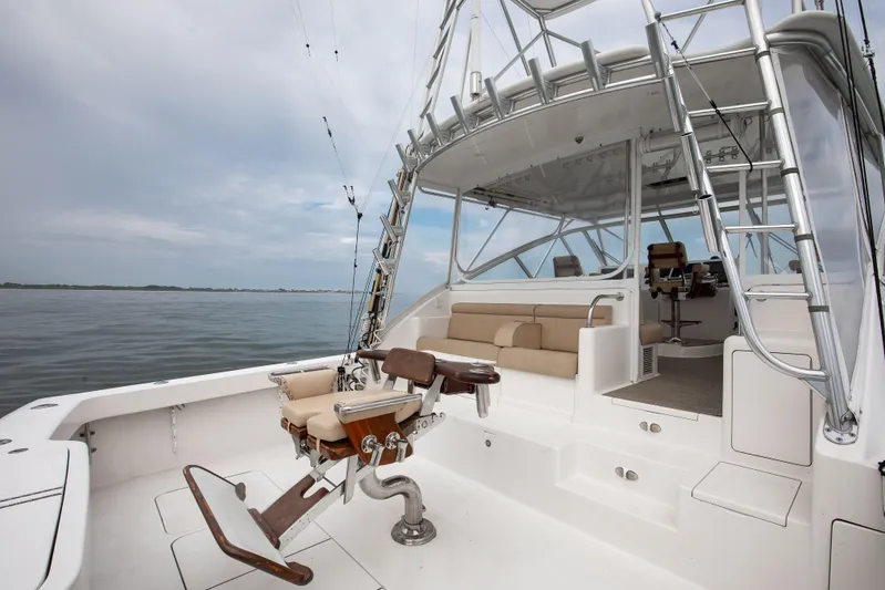 Expresso Yacht Photos Pics 2007 Viking Express boat with fishing chair and seating, on calm waters under cloudy sky.
