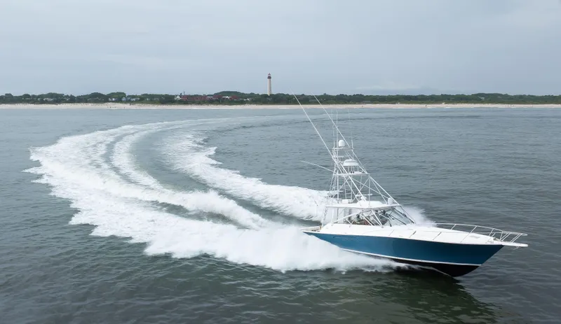 Expresso Yacht Photos Pics 2007 Viking Express boat cruising near a lighthouse on open water.