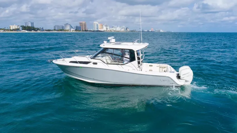  Yacht Photos Pics 2020 Boston Whaler 325 Conquest boat cruising on open ocean near city skyline.