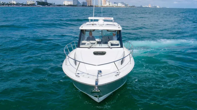  Yacht Photos Pics 2020 Boston Whaler 325 Conquest cruising on open water with city skyline in background.