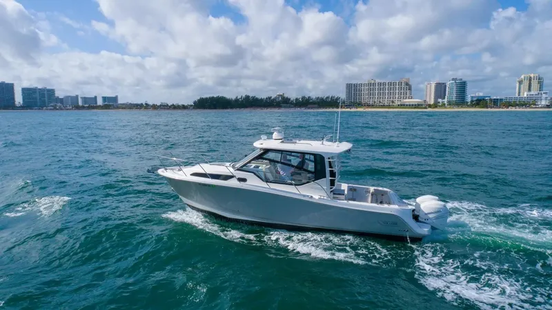  Yacht Photos Pics 2020 Boston Whaler 325 Conquest cruising on ocean near city skyline.
