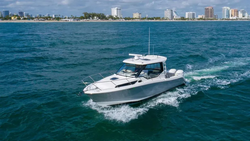  Yacht Photos Pics 2020 Boston Whaler 325 Conquest cruising on ocean near city skyline.
