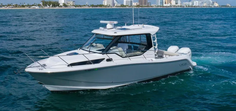  Yacht Photos Pics 2020 Boston Whaler 325 Conquest boat cruising on open water near city skyline.