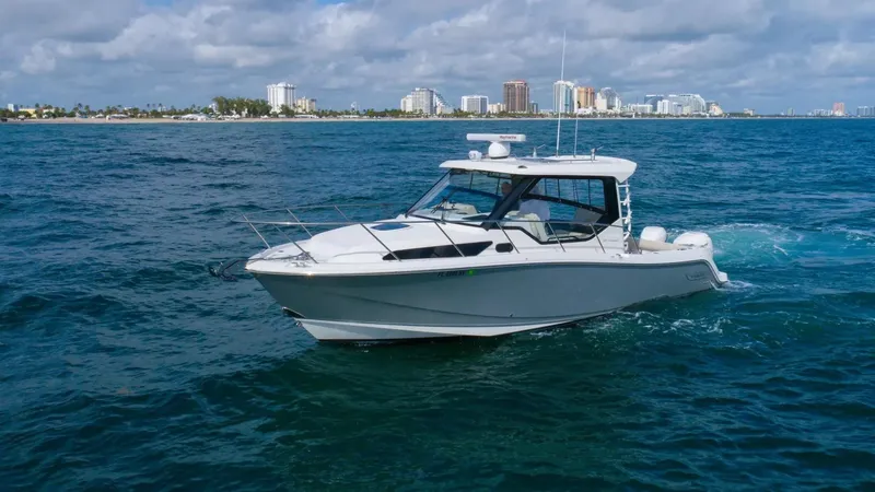  Yacht Photos Pics 2020 Boston Whaler 325 Conquest cruising on blue ocean near city skyline.