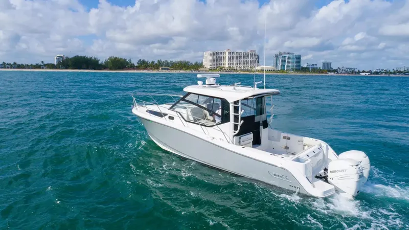  Yacht Photos Pics 2020 Boston Whaler 325 Conquest boat cruising on blue ocean near coastline.