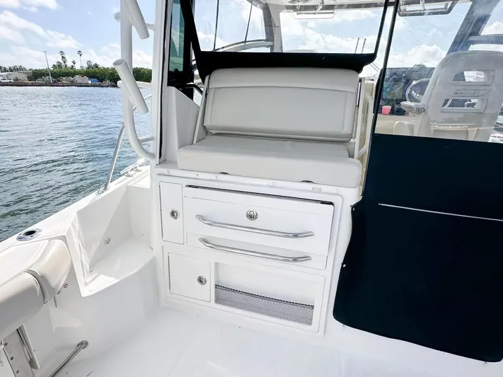  Yacht Photos Pics 2020 Boston Whaler 325 Conquest interior with seating and storage, docked by the water.
