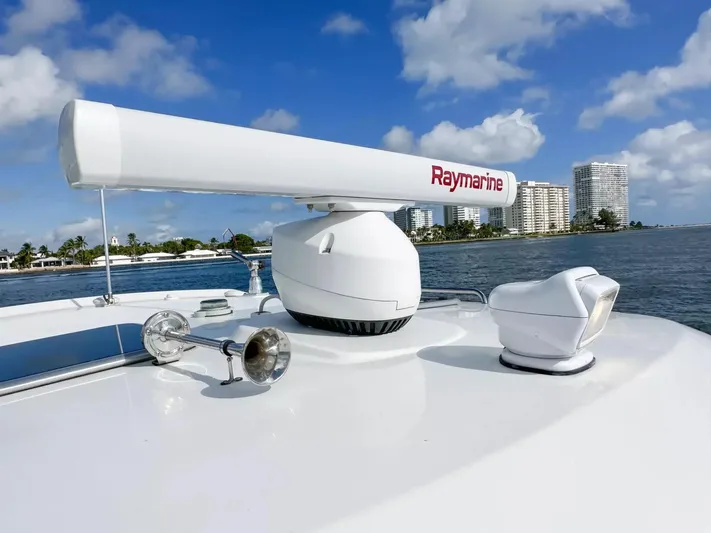  Yacht Photos Pics Boston Whaler 325 Conquest 2020 radar and horn on deck, coastal skyline in background.