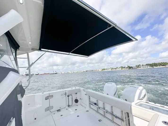  Yacht Photos Pics 2020 Boston Whaler 325 Conquest boat with canopy, cruising on open water.