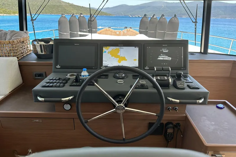 Nm03011 Yacht Photos Pics Helm of 2022 Beneteau Grand Trawler 62 with navigation screens and steering wheel.