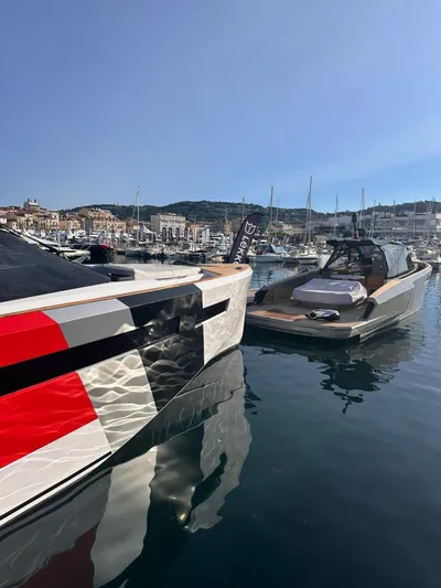  Yacht Photos Pics 2025 Evo Yachts R6+ docked in a scenic marina, reflecting on calm water.