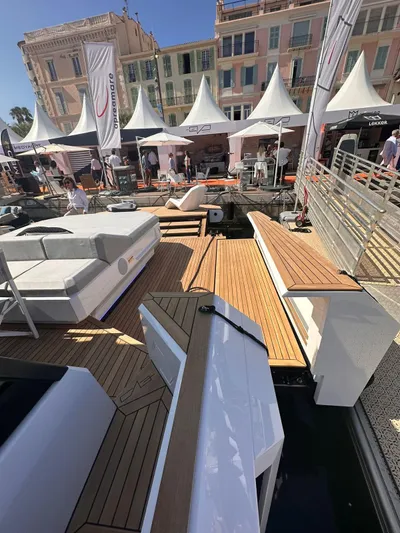  Yacht Photos Pics 2025 Evo Yachts R6+ at a marina with elegant wooden deck and luxury seating.