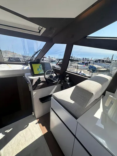  Yacht Photos Pics Interior view of 2025 Evo Yachts R6+ helm with modern controls and marina backdrop.
