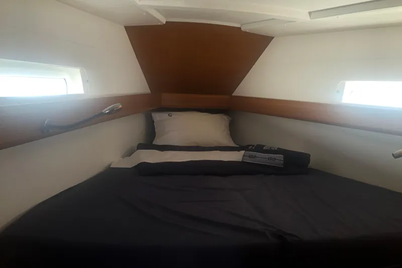  Yacht Photos Pics Cozy cabin interior of 2018 Jeanneau Sun Odyssey 419 sailboat with bed and portholes.