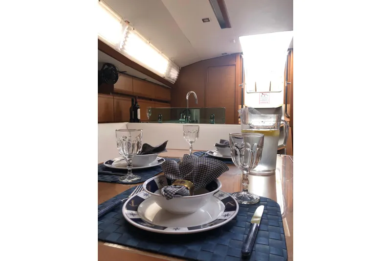  Yacht Photos Pics Elegant dining setup inside 2018 Jeanneau Sun Odyssey 419 yacht, featuring stylish tableware.