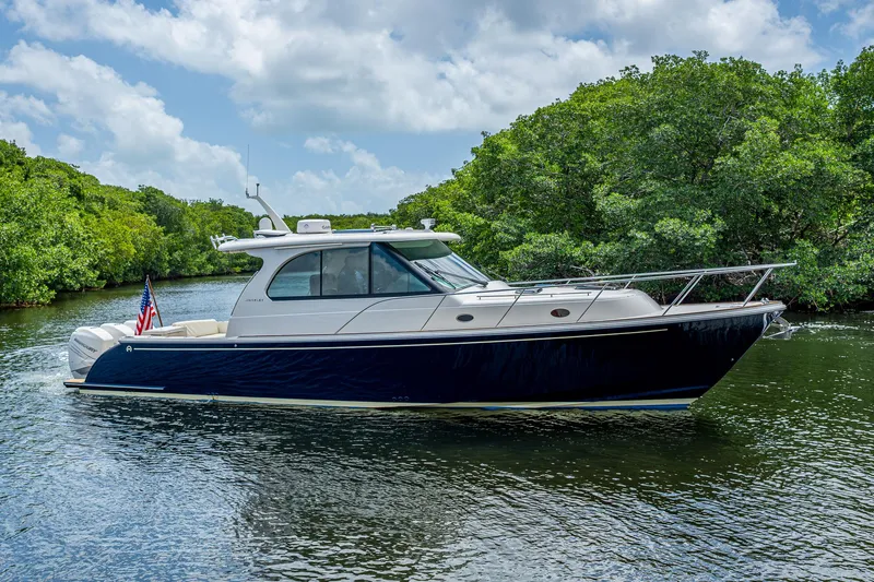 Yes Day Yacht Photos Pics 2021 Hinckley Sport Boat 40 X cruising on a scenic waterway with lush greenery.