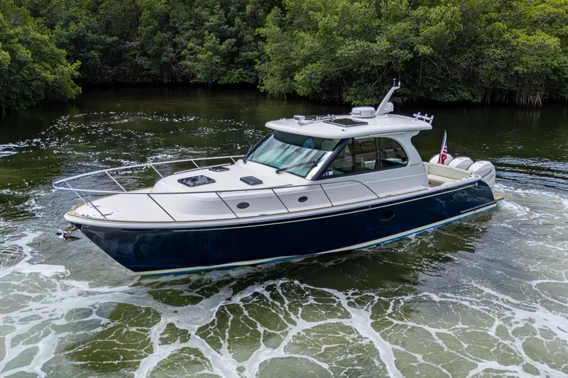 Yes Day Yacht Photos Pics 2021 Hinckley Sport Boat 40 X cruising in a lush, green waterway.