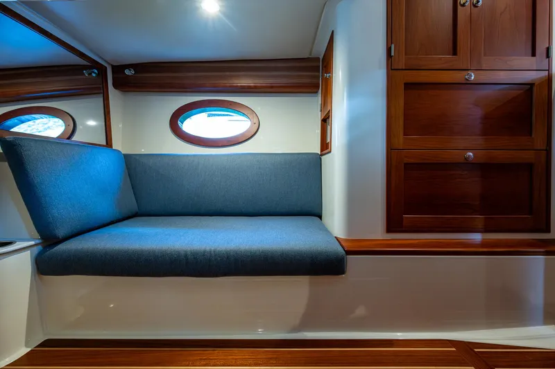 Yes Day Yacht Photos Pics 2021 Hinckley Sport Boat 40 X interior with blue seating and wooden cabinetry.