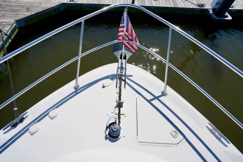 Cheaper II Keep Her Yacht Photos Pics Bow of 2002 Sea Ray 480 Sedan Bridge with American flag at dock.