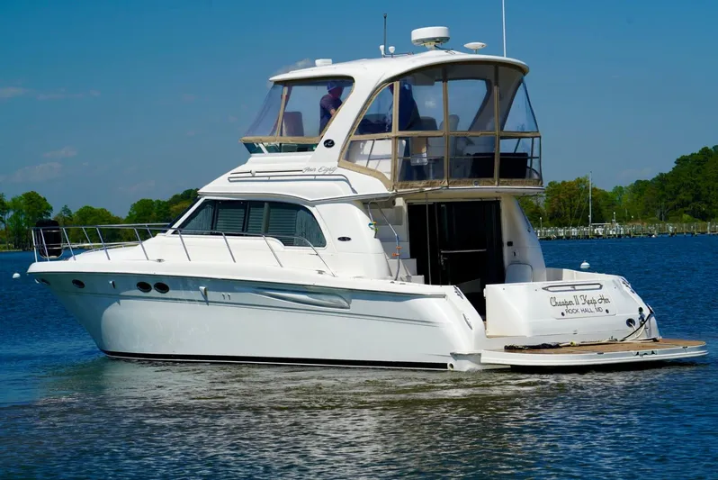 Cheaper II Keep Her Yacht Photos Pics 2002 Sea Ray 480 Sedan Bridge yacht cruising on a calm lake.