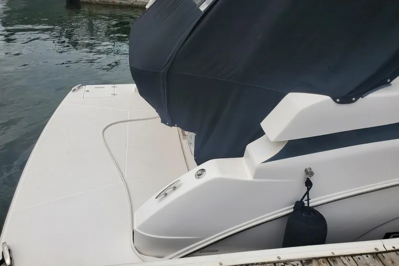 Loml Yacht Photos Pics 2020 Regal 33 Express boat stern view with black cover and docked at marina.