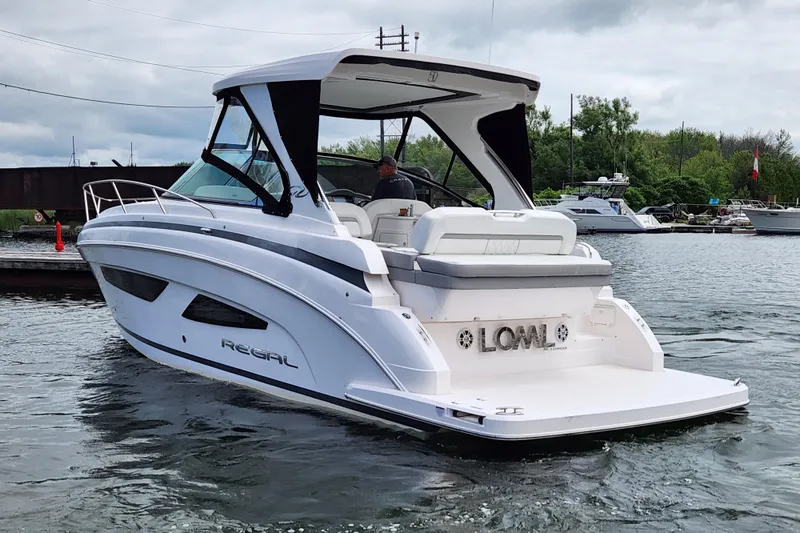 Loml Yacht Photos Pics 2020 Regal 33 Express boat cruising on a calm waterway, overcast sky.