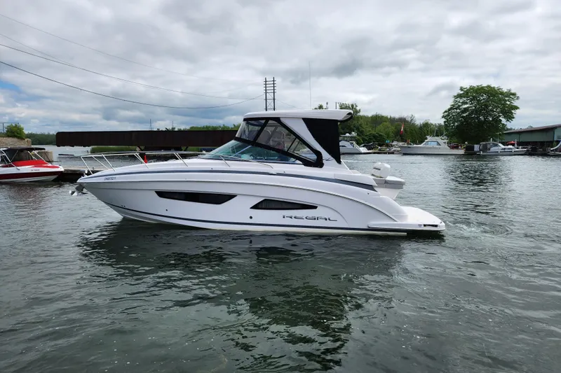 Loml Yacht Photos Pics 2020 Regal 33 Express boat on calm water, overcast sky, marina background.