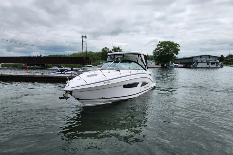 Loml Yacht Photos Pics 2020 Regal 33 Express boat on water near marina under cloudy sky.