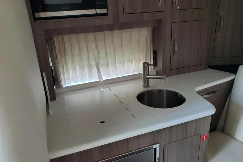 Loml Yacht Photos Pics Compact kitchen area in a 2020 Regal 33 Express boat, featuring a sink and modern cabinetry.
