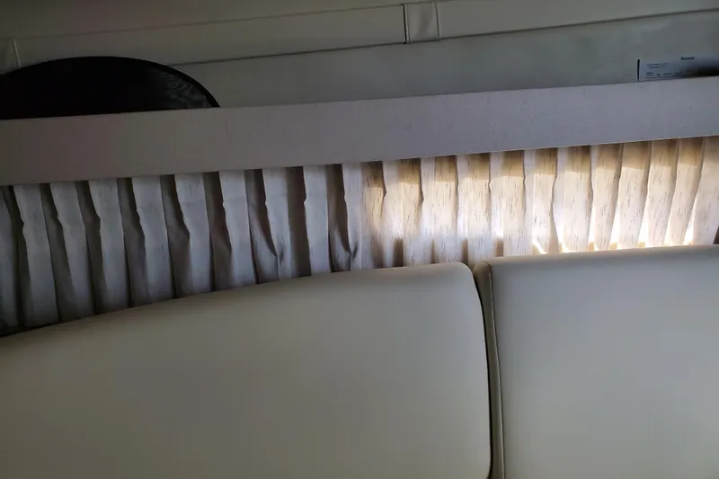 Loml Yacht Photos Pics Interior of 2020 Regal 33 Express boat with pleated curtains and cushioned seating.