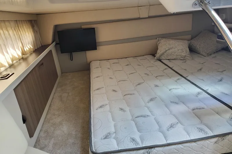 Loml Yacht Photos Pics 2020 Regal 33 Express cabin interior with bed, TV, and storage.