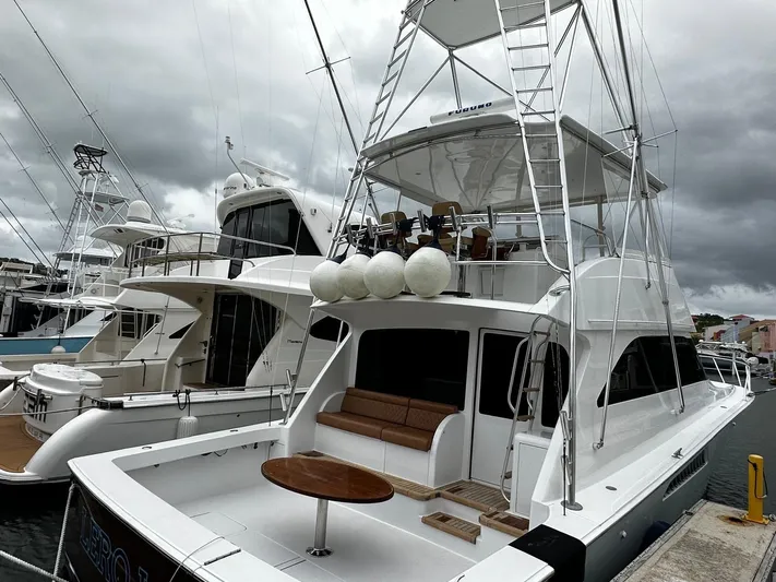  Yacht Photos Pics 2003 Viking 52 yacht docked, featuring a spacious deck and tower under cloudy skies.