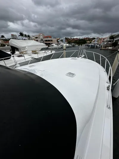 Yacht Photos Pics 2003 Viking 52 yacht docked under cloudy skies in a marina.