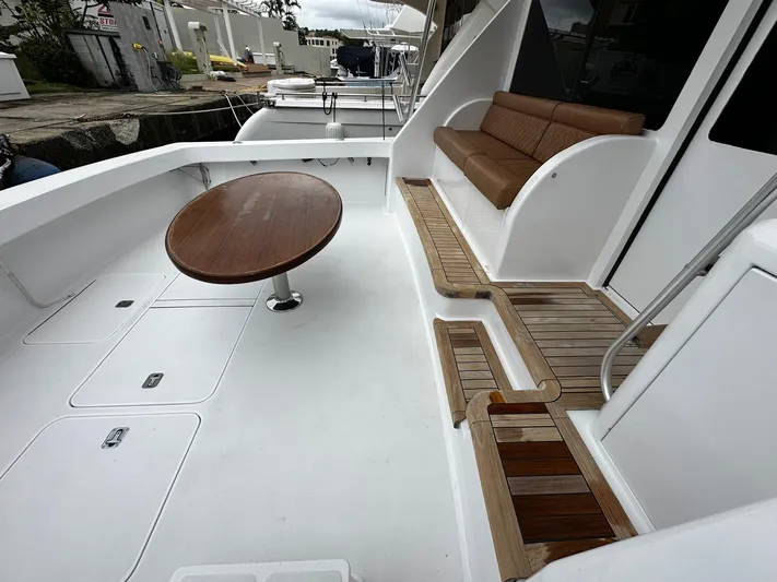  Yacht Photos Pics 2003 Viking 52 yacht deck with seating and wooden table, showcasing luxury marine design.