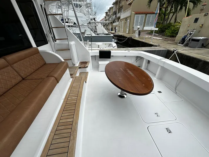  Yacht Photos Pics Spacious deck of 2003 Viking 52 yacht with brown seating and round table.