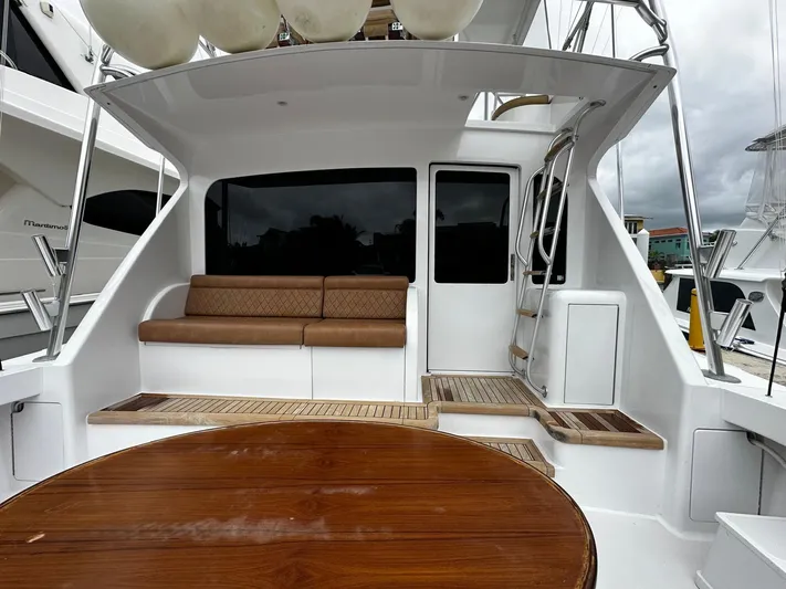  Yacht Photos Pics 2003 Viking 52 yacht cockpit with seating, wooden table, and ladder.