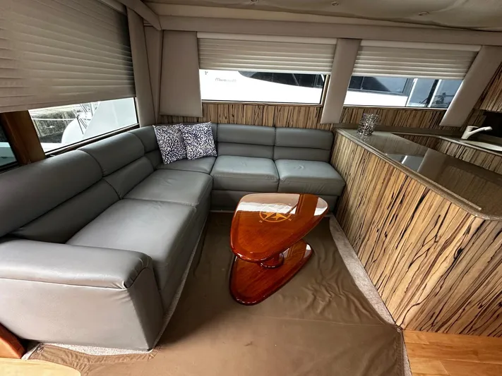  Yacht Photos Pics Luxurious interior of a 2003 Viking 52 yacht with a sleek gray sofa and modern wooden table.