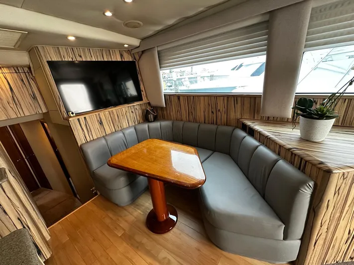  Yacht Photos Pics Luxurious 2003 Viking 52 yacht interior with cozy seating, wooden table, and mounted TV.