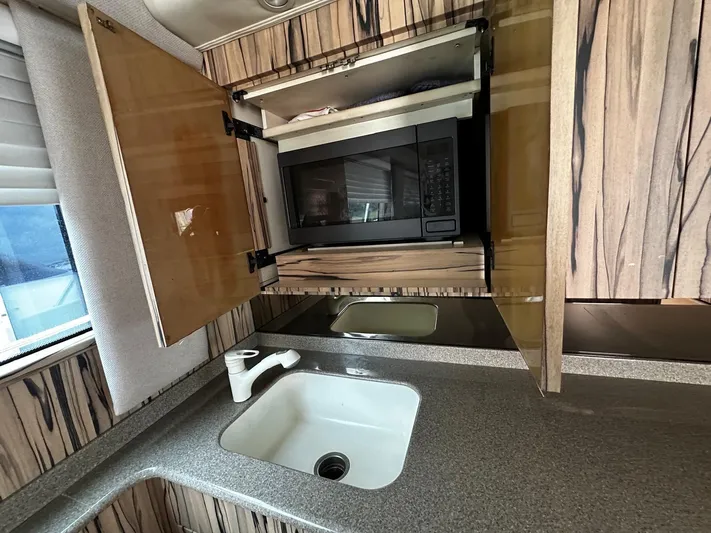  Yacht Photos Pics 2003 Viking 52 kitchen with sink, microwave, and wood cabinets.