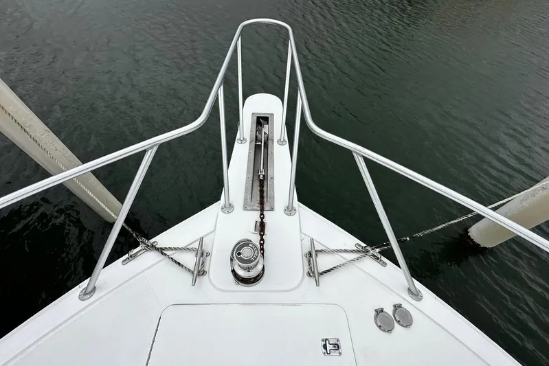  Yacht Photos Pics Bow of 2003 Viking 52 yacht with anchor chain and railing over water.