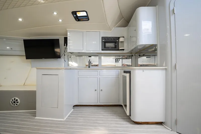 It Is Well Yacht Photos Pics 1997 Strike 42 Express yacht interior with modern kitchen, TV, and sleek cabinetry.