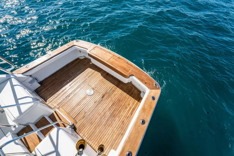 It Is Well Yacht Photos Pics 1997 Strike 42 Express boat deck with teak flooring, overlooking sparkling blue ocean water.